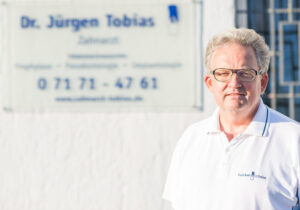 Portrait von Dr. Jürgen Tobias vor dem Praxiseingang